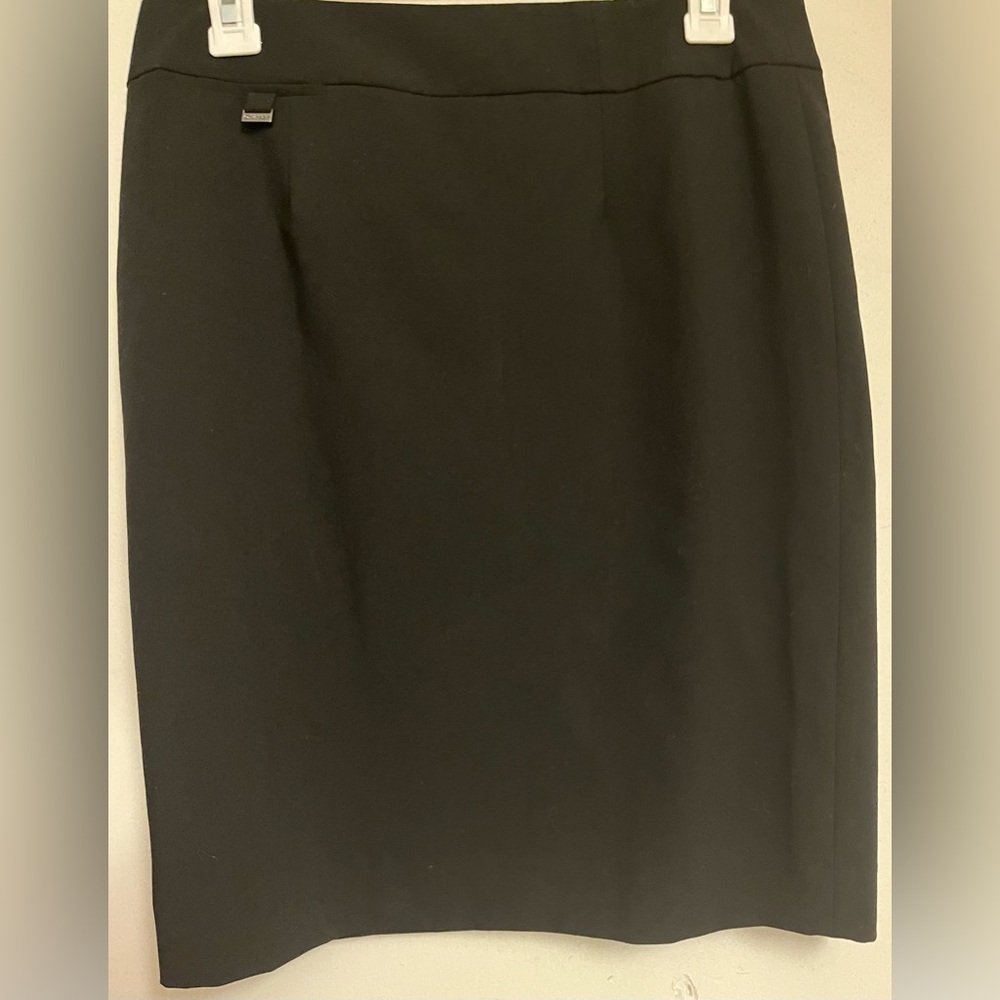 Calvin Klein pencil skirt. With an embellishment in metal on the front top. 6
